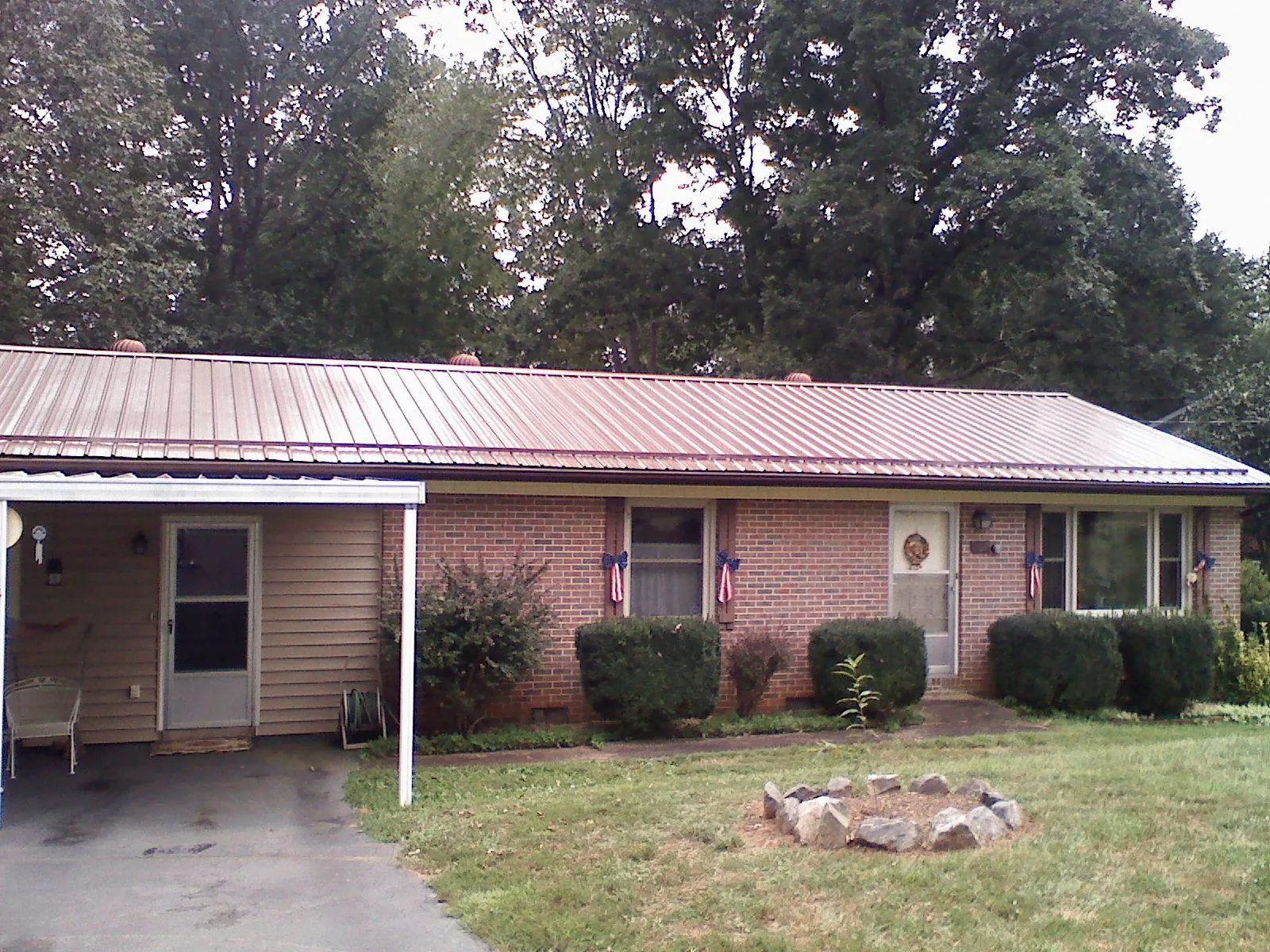 Bronze metal roof and carport on a brick ranch home — Roof Repair work by our crew in Portland